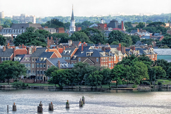 A charming street scene in Old Town Alexandria, Virginia, featuring brick buildings, cobblestone streets.