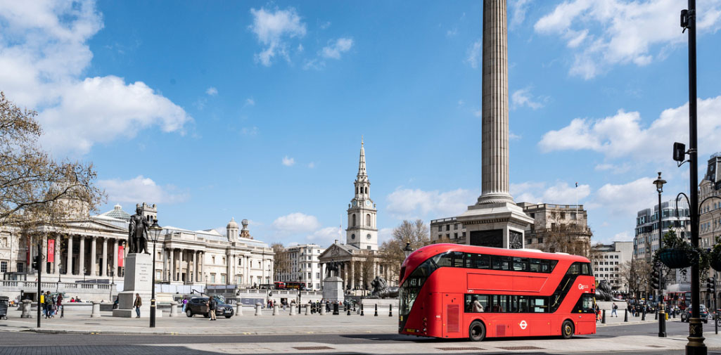 Red bus driving through central London
