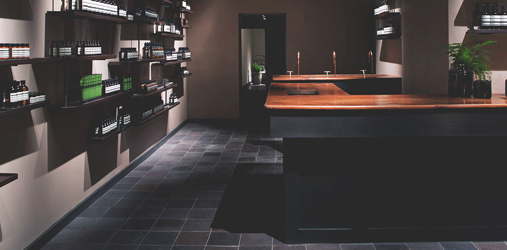 Aesop store - Shelves stacked with toiletries opposite a shop counter